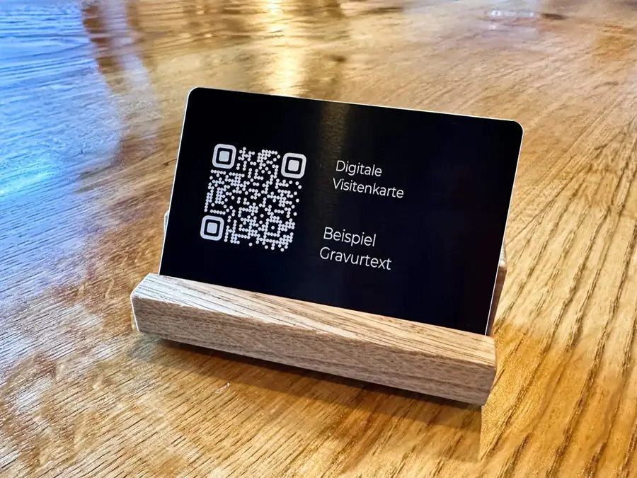 Schwarze Metallkarte mit gravierter Beispielschrift in einem Holzständer