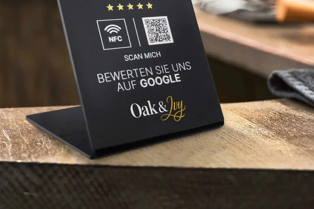 Schwarzer NFC-Aufsteller mit NFC-Symbol und QR-Code auf einem Tresen
